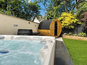 Ein Whirlpool mit einer Holzbottensauna, einem Schild mit der Aufschrift 'COLD PLUNGE' und einem Schild mit der Aufschrift 'VERY HOT'.