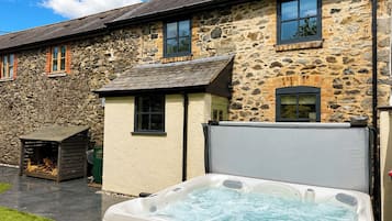 Un bâtiment en pierre avec un jacuzzi à l’avant.