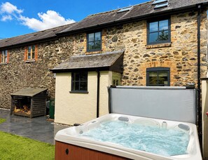 Un edificio de piedra con un jacuzzi en primer plano.
