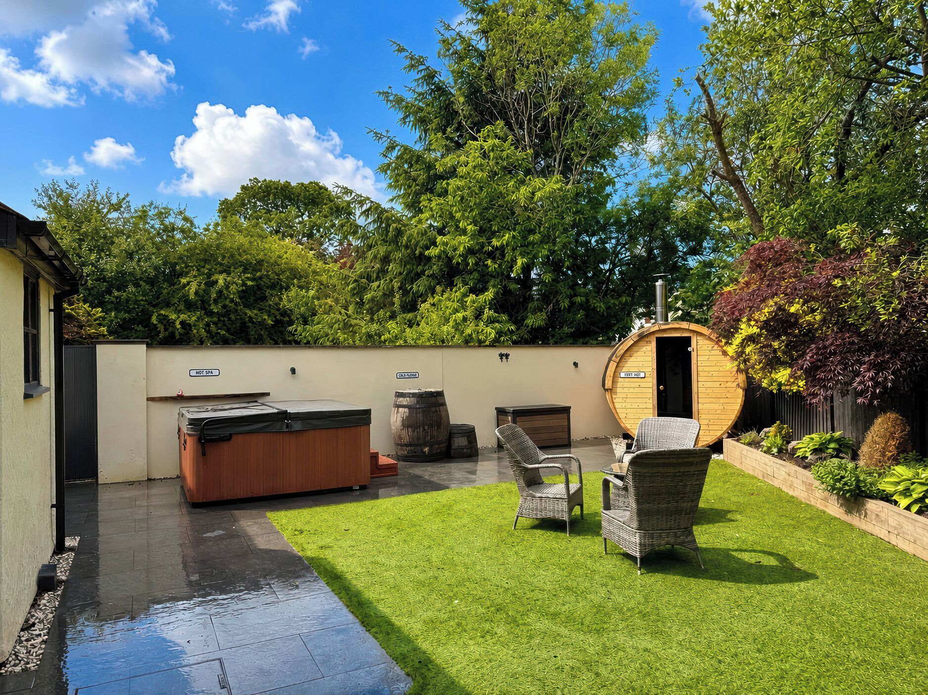 A spa area with a hot tub, seating, and a wooden barrel.