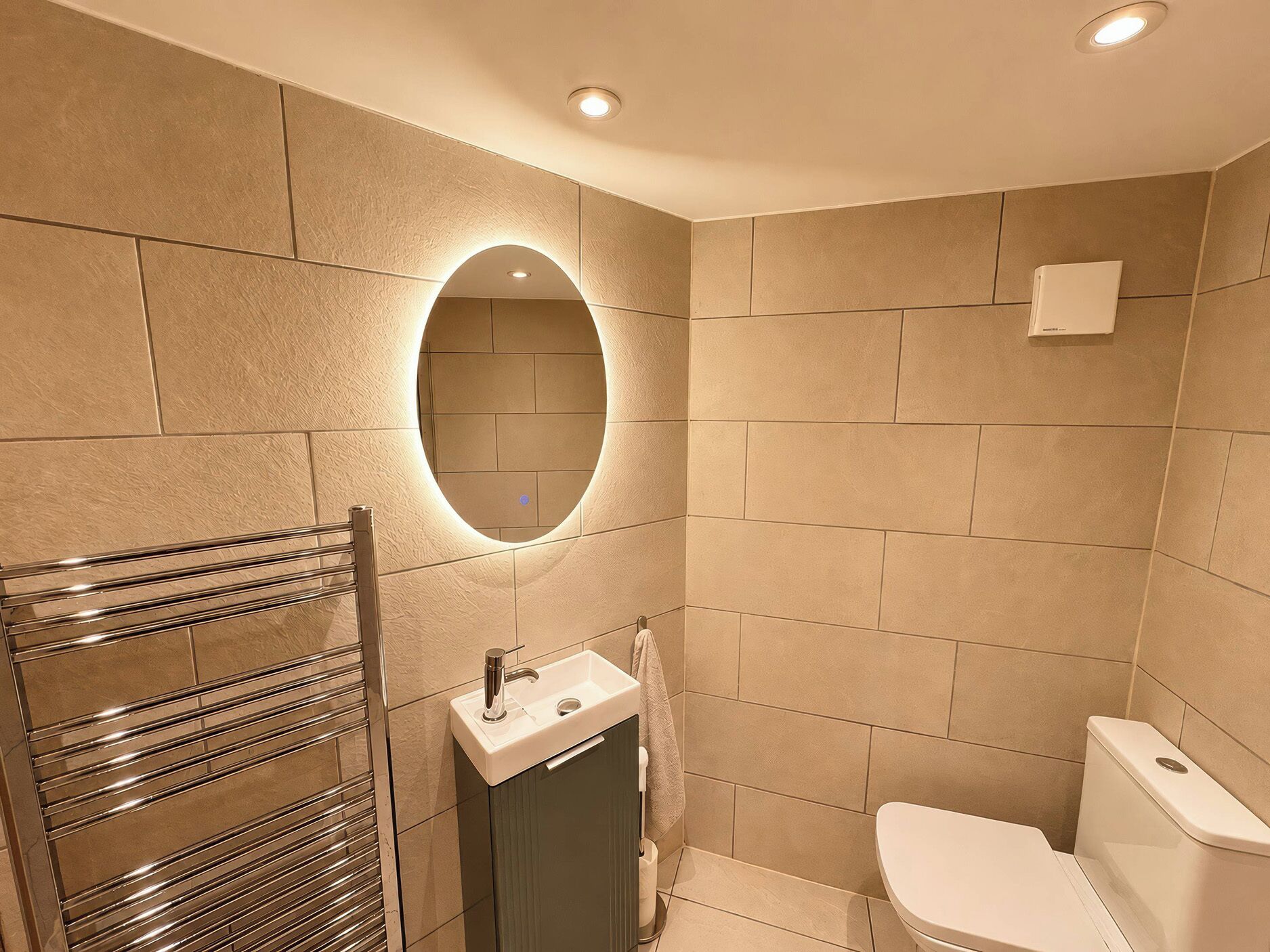 A bathroom with a mirror, sink, toilet, and towel rack.