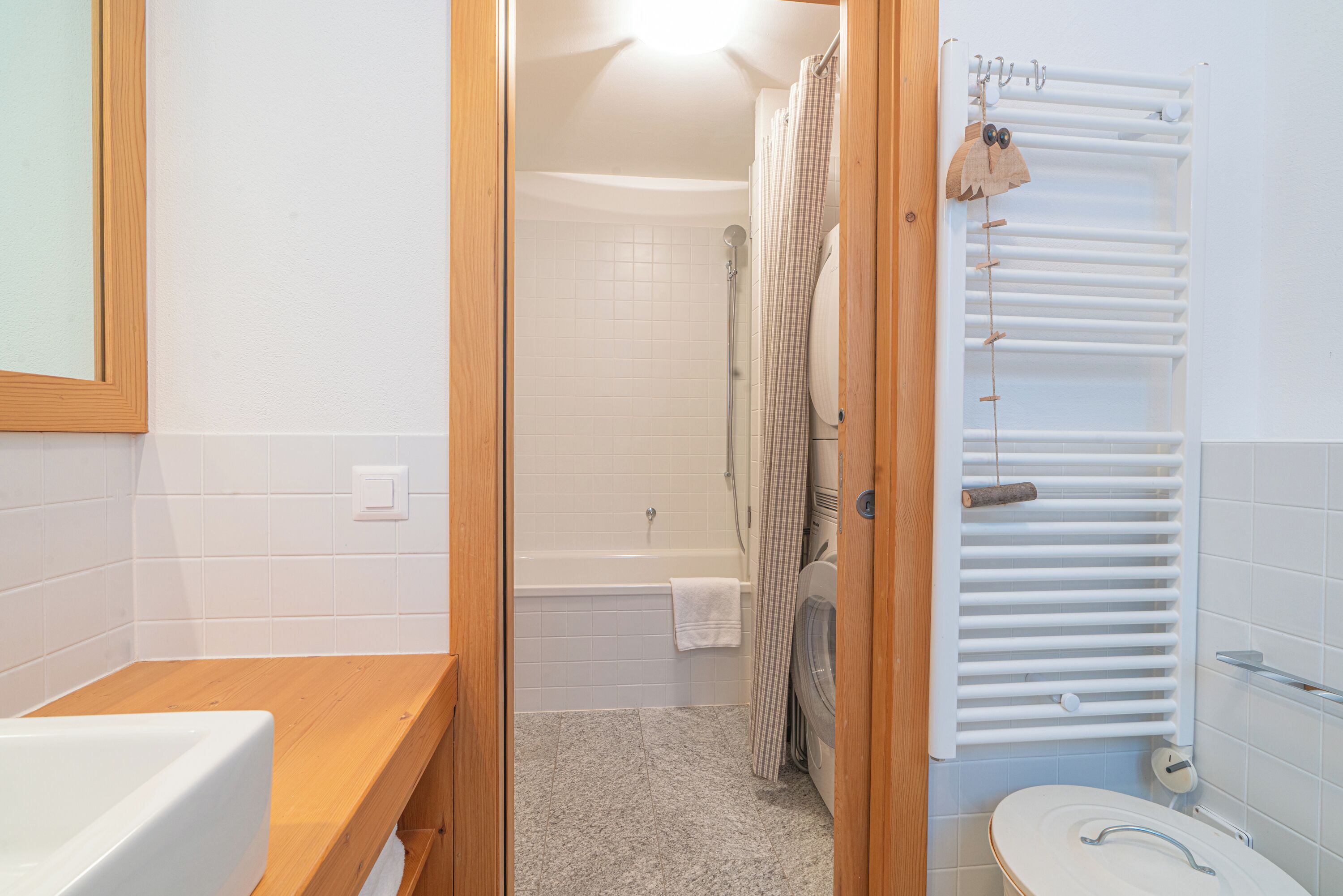 A bathroom with a wooden vanity, a bathtub, a shower, and a toilet.