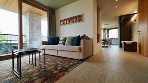 Ein modernes Wohnzimmer mit einer Couch, einem Couchtisch und einem farbenfrohen Teppich.