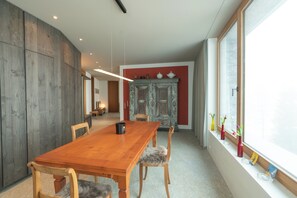Ein Essbereich mit Holztisch, Stühlen und einer Kommode mit Dekoration.