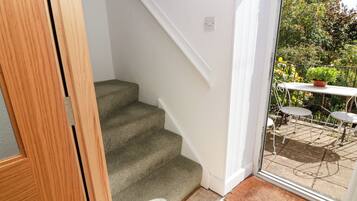 A wooden door leading to a staircase with a textured carpet.