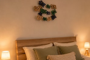 Une chambre à coucher avec une tête de lit en bois, deux lampes de chevet et un élément décoratif mural.