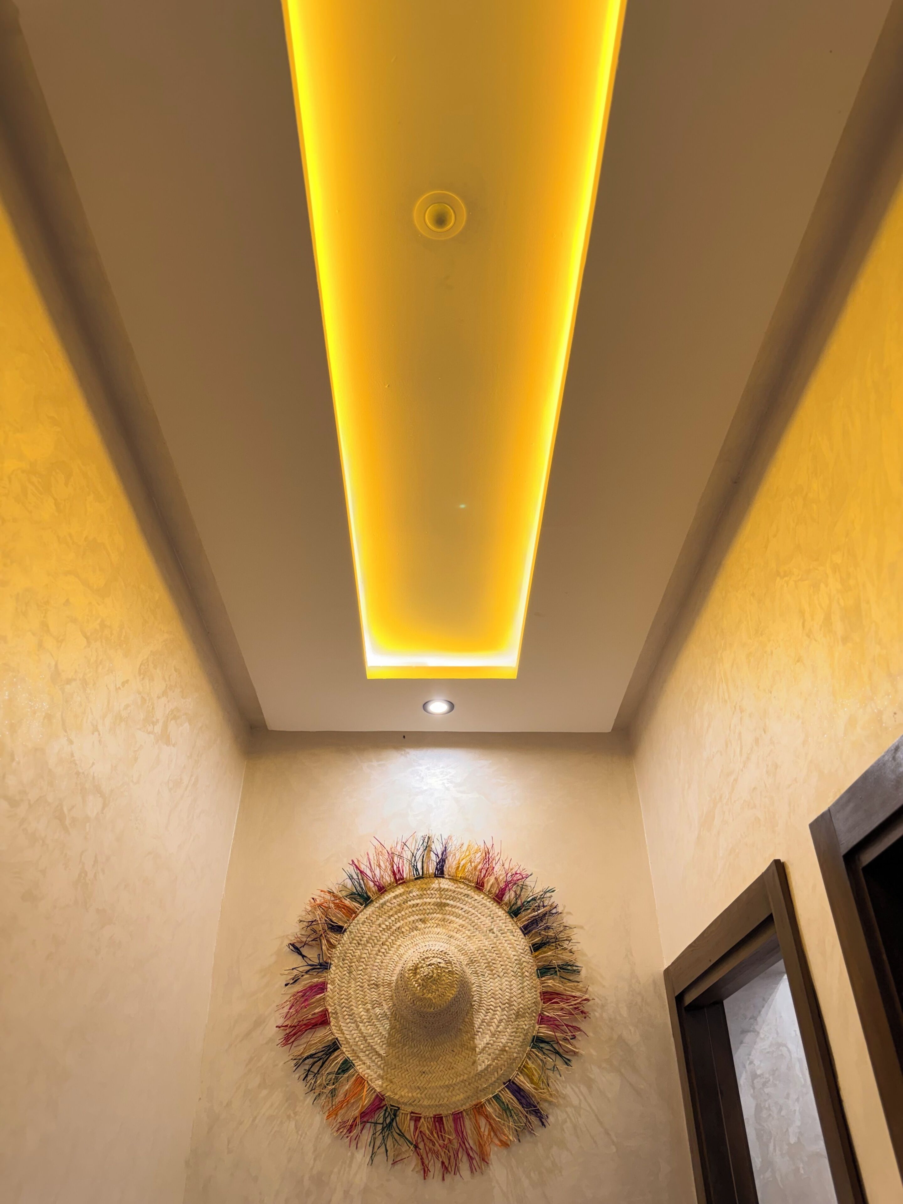 A ceiling with recessed lighting and a decorative wall piece.
