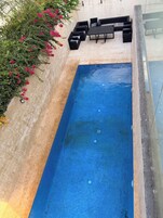 Una piscina al aire libre, sombrillas, tumbonas