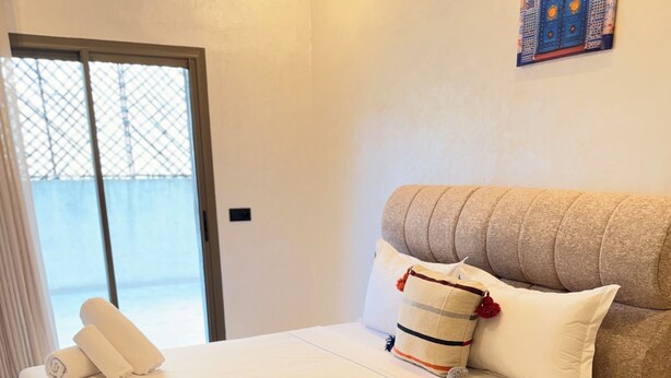 Un dormitorio con una cama grande, una mesita de noche de madera y un adorno en la pared.