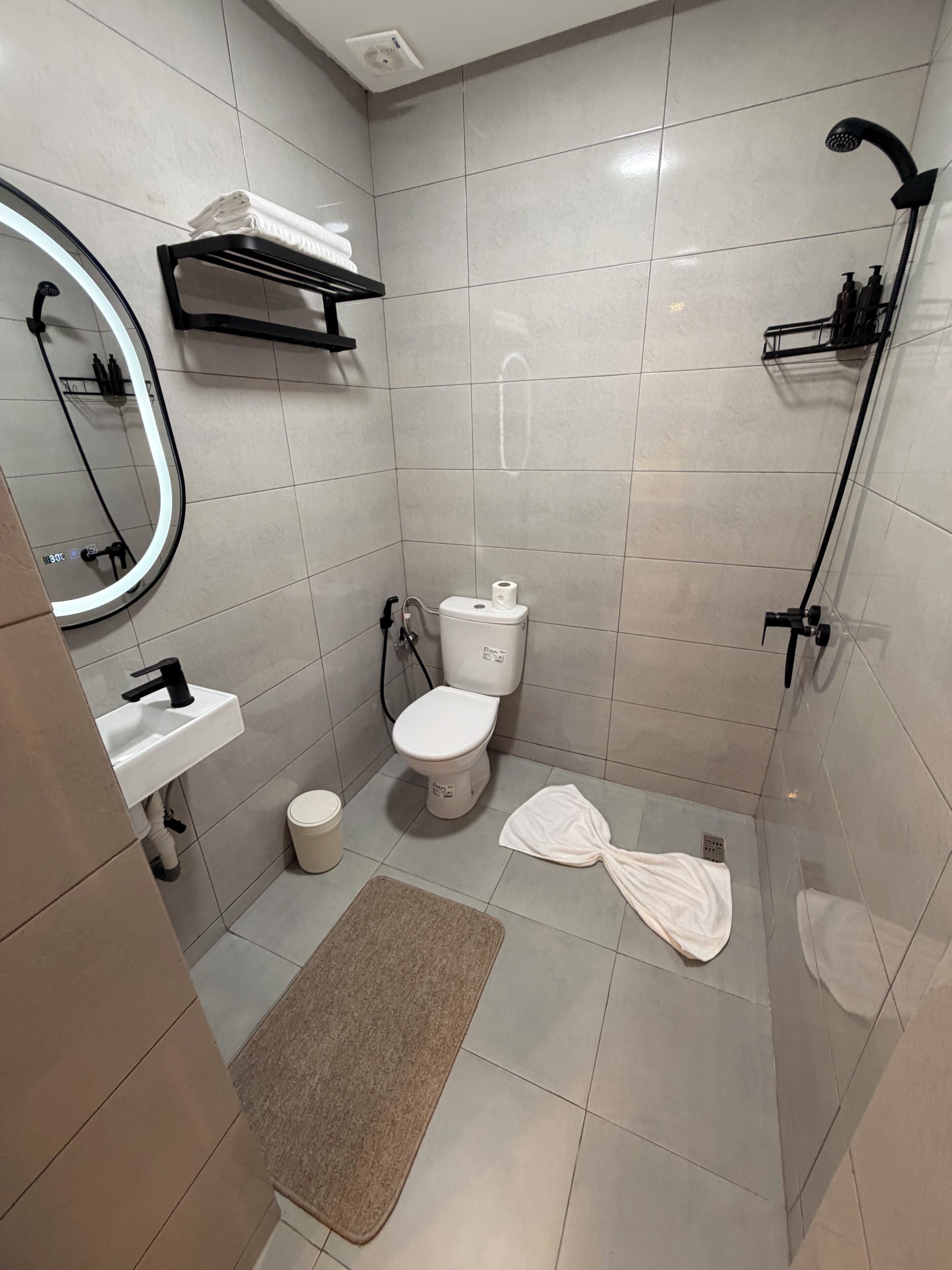 A modern bathroom with a toilet, sink, and shower.