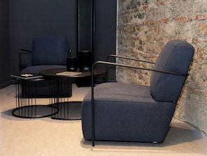 A modern room with a blue armchair, a round black table, and a dark blue sofa. - Made To Measure Catania Centro (Catania)