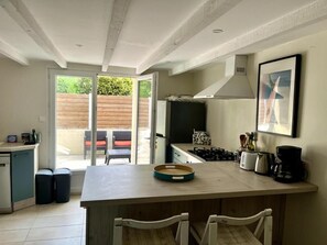 A modern kitchen with a central island, a gas stove, and a coffee maker. - Charming Charentaise house, ideal for peaceful vacations. (Saint-Palais-sur-Mer)