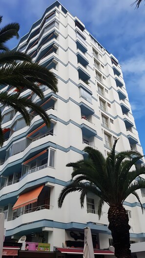 Um hotel de vários andares com design moderno, apresentando varandas e um telhado plano.