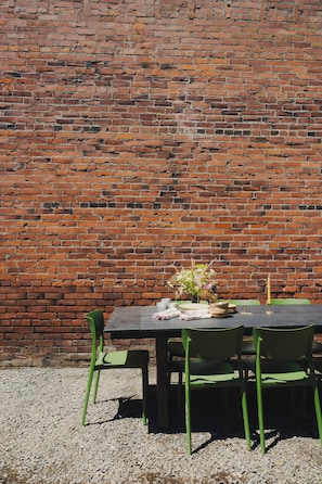 An outdoor table with chairs against a brick wall. - The Apartment at Lucky Duck - 2 bedrooms in a historic restored bank (Carlton)
