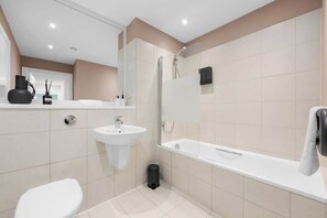Ein modernes Badezimmer mit Toilette, Waschbecken und Dusche.