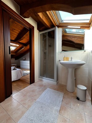 Un bagno con doccia, lavandino e WC.