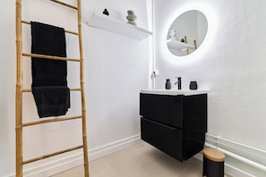 A bathroom with a white vanity, black cabinets, a round mirror, a wooden ladder, and a small stool. - Le Pinterest - Downtown - Near train station (Reims)