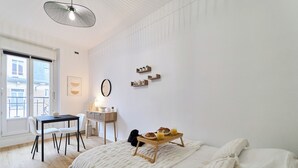 Un dormitorio con cama, mesita de noche y bandeja para el desayuno.