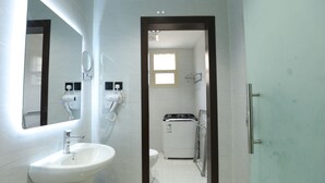 Un baño con lavamanos, espejo e inodoro.