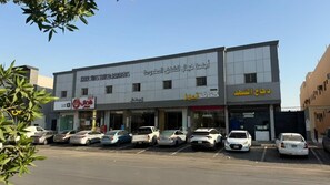 A commercial building with multiple storefronts, including a service department and a restaurant. - khayal suites (Riyadh)
