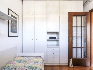 A bedroom with a bed, a wardrobe, a door with frosted glass panels, and a framed picture on the wall. - Casa di Flavia by Interhome (Riva Ligure)