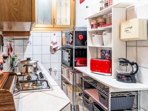 A kitchen with a gas stove, oven, microwave, and a coffee maker. - Margherita Home by Interhome (Sanremo)