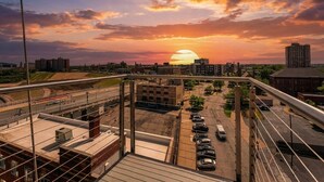 A sunset view from a high-rise building with a parking lot and urban landscape in the foreground. - Modern 1BR Penthouse  Heart of CLE Views (Cleveland)