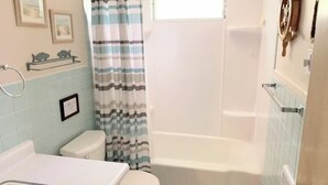 Ein Badezimmer mit Badewanne, Toilette und Duschvorhang.