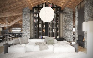 Ein gemütliches Wohnzimmer mit Kamin aus Stein, einer großen Bücherwand und einem modernen Sofa.