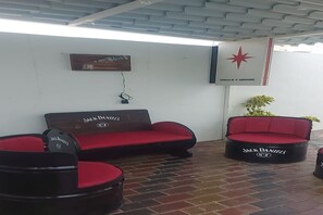 A seating area with two Jack Daniel's branded sofas and chairs, a wall-mounted picture, and a Stella Artois sign.