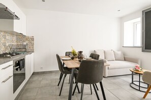 Eine moderne Küche mit Essbereich, einer Couch und einem kleinen Tisch mit Blumen.