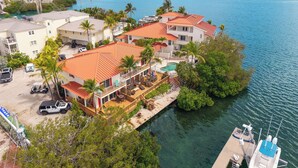 A coastal residential area with houses, a dock, and a clear view of the sea. - SALTWATER SOUL - 2 Bedroom / 2.5 Bathroom Waterfront Townhome W/ Shared Pool (Key West)