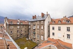 Ein mehrgeschossiges Gebäude mit Innenhof, Balkonen und verschiedenen Fensterformen.