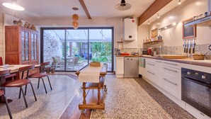 Una cucina moderna con zona pranzo, ampie finestre e vista sul verde.