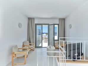 A modern room with a balcony, wooden furniture, and a television. - Villa Iliada - Paros Escape (Paros)