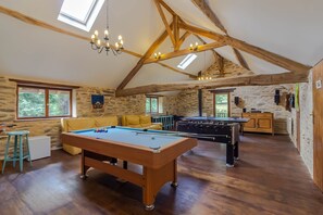 A spacious room with a pool table, a foosball table, and a sofa. - La Parenthèse Fleurie - Avec Piscine Privée (Saint-Priest-les-Fougères)