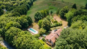 Et boligområde med swimmingpool, et hus og grøn beplantning omkring.
