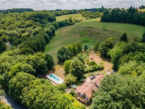 A residential area with a swimming pool, a house, and surrounding greenery. - La Parenthèse Fleurie - Avec Piscine Privée (Saint-Priest-les-Fougères)