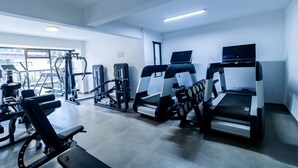 Ein Fitnessstudio mit Laufbändern, Kraftgeräten und einem Rudergerät.