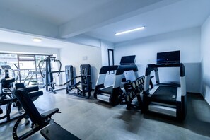 Ein Fitnessstudio mit Laufbändern, Kraftgeräten und einem Rudergerät.