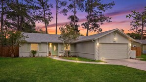 A single-story house with a front porch, a garage, and a well-maintained lawn.