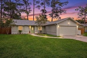 A single-story house with a front porch, a garage, and a well-maintained lawn.