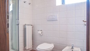 A bathroom with a glass shower enclosure, a toilet, a bidet, and a radiator. - COUNTRY HOUSE (Greve in chianti)