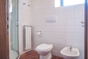 A bathroom with a glass shower enclosure, a toilet, a bidet, and a radiator. - COUNTRY HOUSE (Greve in chianti)