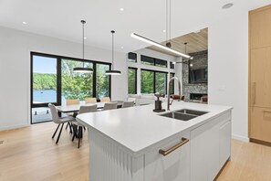 Una cocina moderna con una isla grande, un comedor con vistas y una chimenea.