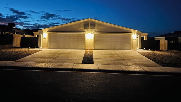 A modern two-car garage with a concrete driveway and illuminated garage doors. - 3 bedroom house with AC in charming Kingman Near The Hospital Top restaurants (Kingman)