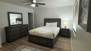 A bedroom with a bed, dresser, nightstand, ceiling fan, and a rug. - 3 bedroom house with AC in charming Kingman Near The Hospital Top restaurants (Kingman)