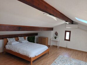 A bedroom with a wooden bed, a small white dresser, a mirror, and a window. - Vrbo Property (Marseille)