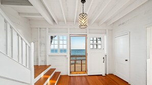 A wooden staircase leading to a door with a view of the sea. - Oceana: Beachfront Estate, Period Charm, Sleeps 8 (South Kingstown)