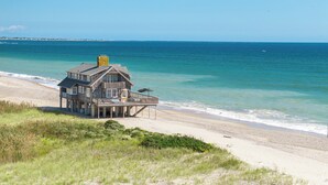 A beachfront house with a balcony, a chimney, and a view of the ocean. - Oceana: Beachfront Estate, Period Charm, Sleeps 8 (South Kingstown)